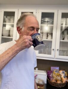 man drinking from a black coffee mug